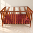 Wooden Baby Cot with Mattress in a neutral room