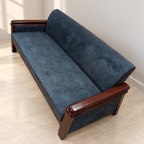 Blue Fabric Three-Seater Sofa with Wooden Arms in a neutral room