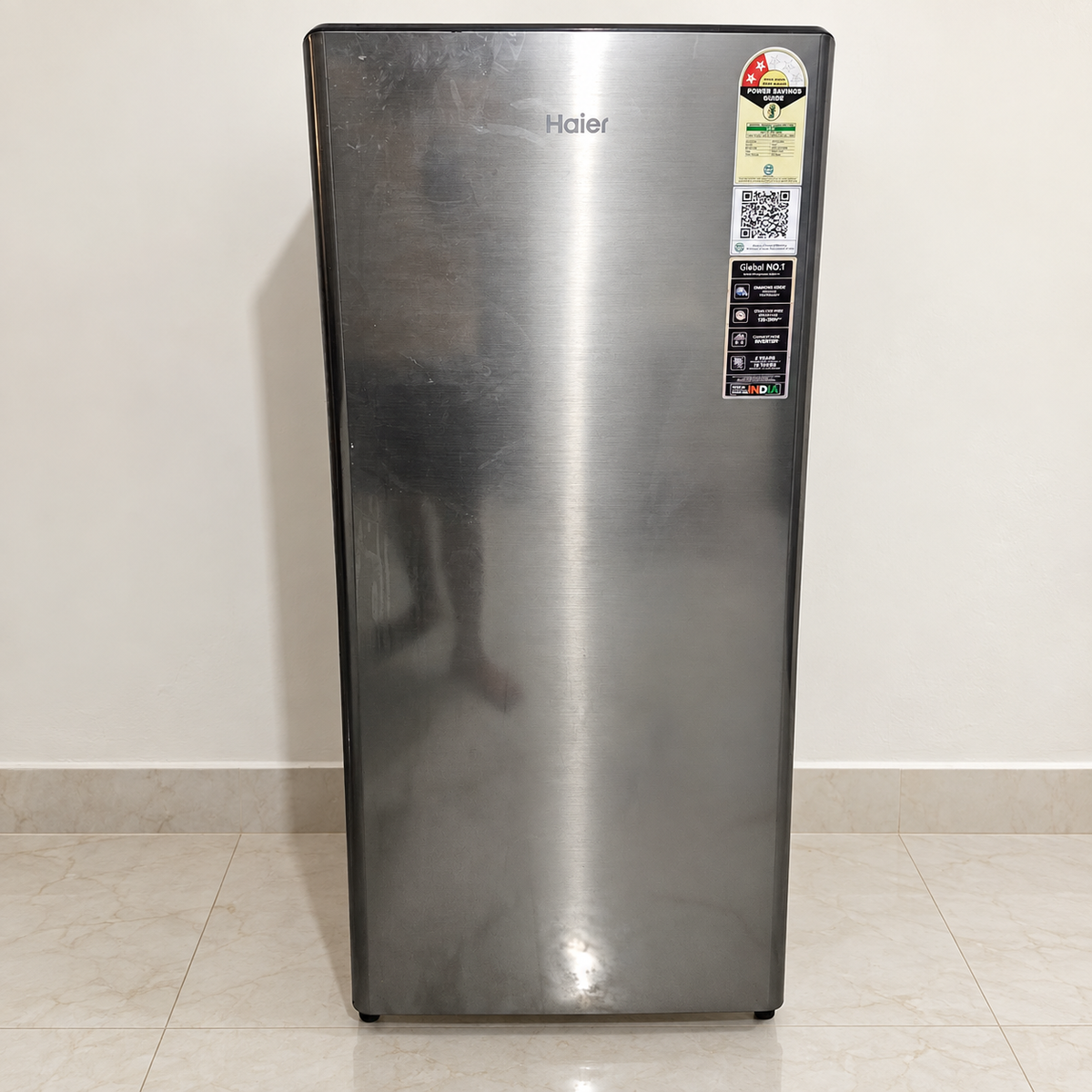 Pre-owned Haier 215 L single-door refrigerator with smudges visible