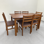 Pre-owned brown six-seater dining set with light tabletop marks in a neutral room