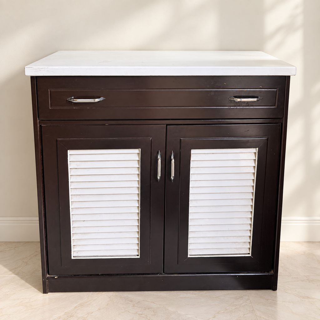 Dark brown shoe cabinet with white top, drawer and louvered doors; light wear visible