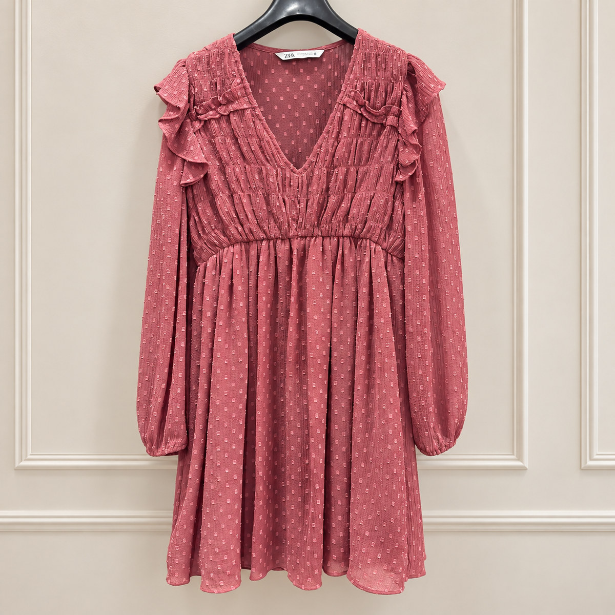 Pre-owned pink Zara ruffle dress with long sleeves on hanger in neutral setting
